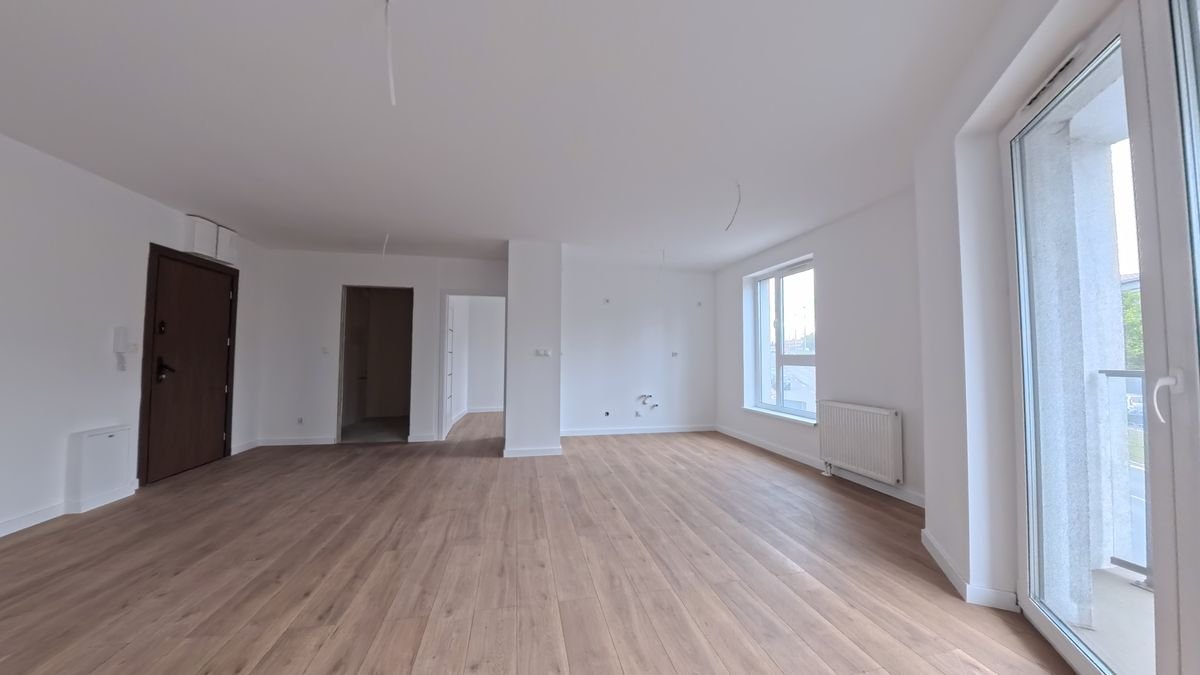Przykładowe mieszkanie w Odrzańskich Bulvarach w Szczecinie – salon z ułożoną podłogą i pomalowanymi ścianami, wyjście na balkon, zdjęcie rzeczywiste