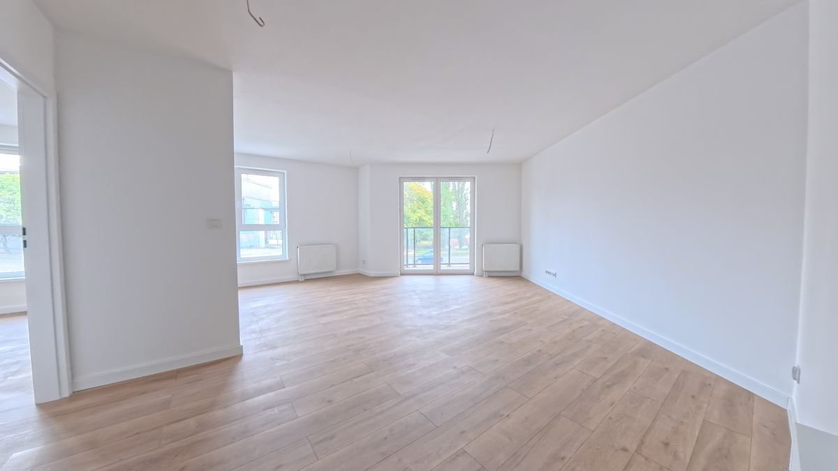 Salon przykładowego mieszkania w Odrzańskich Bulvarach w Szczecinie z oknem i wyjściem na balkon, zdjęcie rzeczywiste